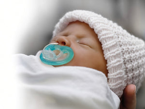 JollyPop Newborn teal pacifier in use by sleeping newborn